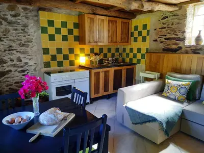 a kitchen and living room with a table and a couch at Galicia Retreat in Santa Marta de Ortigueira