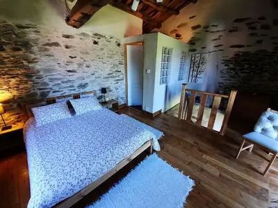 a bedroom with a bed and a stone wall at Galicia Retreat in Santa Marta de Ortigueira