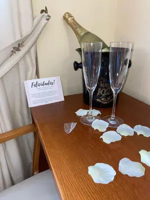 two wine glasses and a bottle on a wooden table at Hotel Condes De Lemos España in Monforte de Lemos