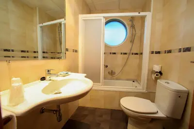 a bathroom with a sink and a toilet and a window at Hotel Condes De Lemos España in Monforte de Lemos
