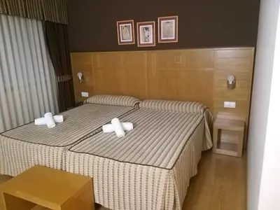 two beds in a hotel room with white pillows at Hotel Condes De Lemos España in Monforte de Lemos