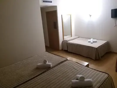 two beds in a hotel room with towels on them at Hotel Condes De Lemos España in Monforte de Lemos