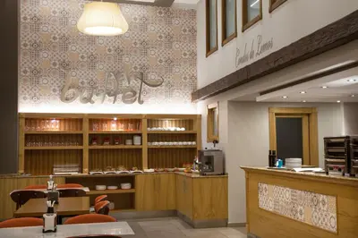 a restaurant with a counter and chairs in a room at Hotel Condes De Lemos España in Monforte de Lemos