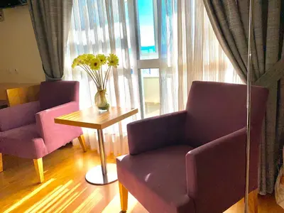 a living room with two chairs and a table with flowers at Hotel Condes De Lemos España in Monforte de Lemos