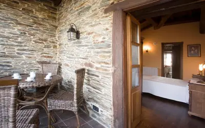a room with a table and chairs and a bedroom at Balcón de Oscos in Santa Eulalia de Oscos