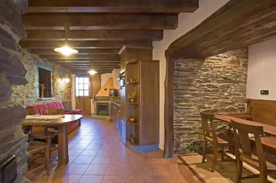 a kitchen and dining room with a stone wall at Balcón de Oscos in Santa Eulalia de Oscos