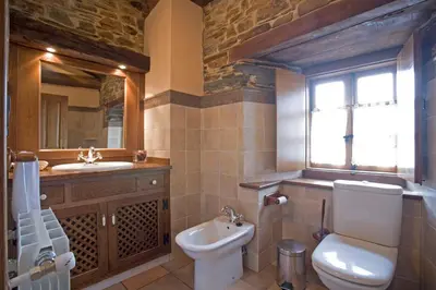 a bathroom with a toilet and a sink and a window at Balcón de Oscos in Santa Eulalia de Oscos