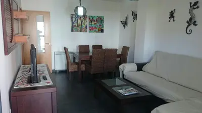 a living room with a couch and a table at Apartamento Viveiro, Terraza Grande, 2 dormitorios 2 baños, piscinas, parking, tenis, club social in Jove