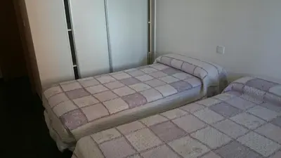 two twin beds in a room with at Apartamento Viveiro, Terraza Grande, 2 dormitorios 2 baños, piscinas, parking, tenis, club social in Jove