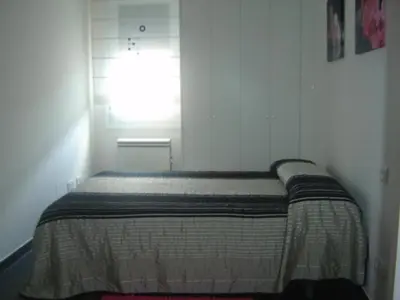 a bed in a white room with a window at Apartamento Viveiro, Terraza Grande, 2 dormitorios 2 baños, piscinas, parking, tenis, club social in Jove