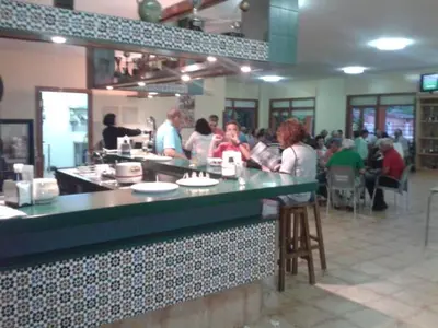 a group of people sitting at a counter in a restaurant at Apartamento Viveiro, Terraza Grande, 2 dormitorios 2 baños, piscinas, parking, tenis, club social in Jove