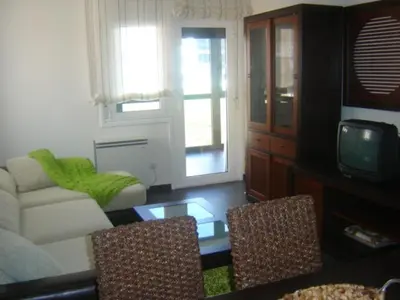 a living room with a couch and a tv at Apartamento Viveiro, Terraza Grande, 2 dormitorios 2 baños, piscinas, parking, tenis, club social in Jove