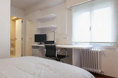 a bedroom with a bed and a desk with a computer at Pension Residencia F&F in Santiago de Compostela