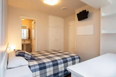 a small room with a bed and a mirror at Pension Residencia F&F in Santiago de Compostela