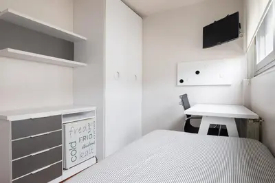 a small bedroom with a bed and a desk at Pension Residencia F&F in Santiago de Compostela