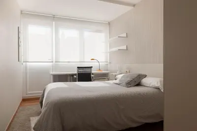 a bedroom with a bed and a desk and a window at Pension Residencia F&F in Santiago de Compostela