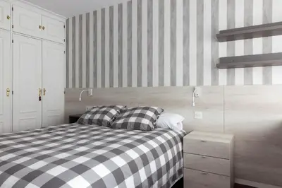 a bedroom with a bed and a striped wall at Pension Residencia F&F in Santiago de Compostela