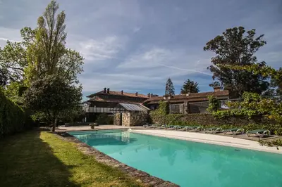 a swimming pool in front of a house at Pazo da Merced in Neda