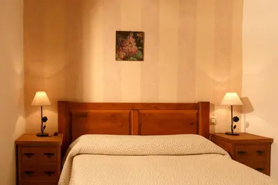 a bedroom with a bed and two night stands with lamps at Lugar dos Devas in Covelo