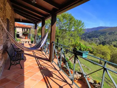 a porch with a hammock on a house at Lugar dos Devas in Covelo