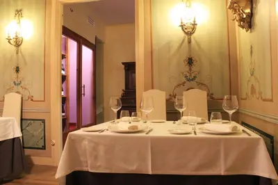 a table with a white table cloth and wine glasses at Hostal Siglo XIX in Cacabelos