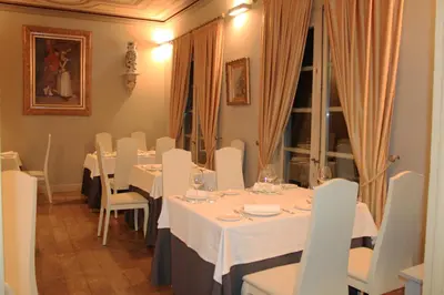 a dining room with white tables and white chairs at Hostal Siglo XIX in Cacabelos