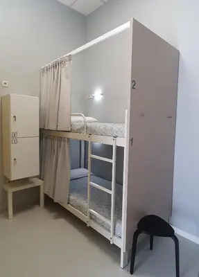 a room with two bunk beds and a chair at Albergue Turistico la Credencial in Santiago de Compostela