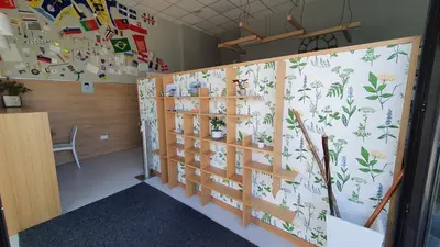 a room with a wall covered in magnets and plants at Albergue Turistico la Credencial in Santiago de Compostela