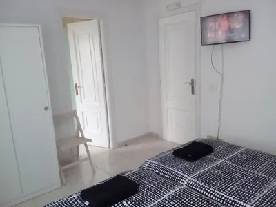 a bedroom with a bed and a tv on the wall at Albergue Aqua Portomarin in Portomarin