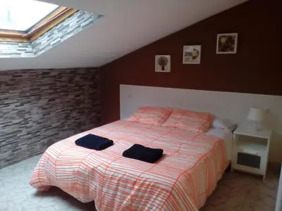 a bedroom with a bed with two black towels on it at Albergue Aqua Portomarin in Portomarin