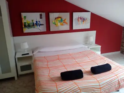 a bedroom with a bed with two black pillows on it at Albergue Aqua Portomarin in Portomarin