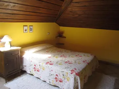 a bedroom with a bed and a yellow wall at A Lareira in Chan de Vilar