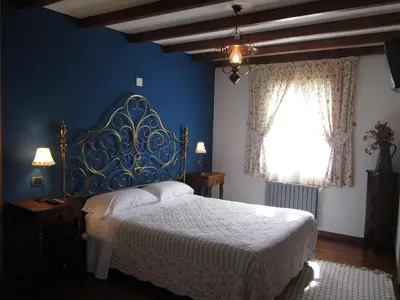a bedroom with a bed and a blue wall at A Lareira in Chan de Vilar
