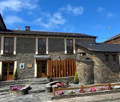 a stone house with a fence in front of it at Casa Ría de Navia in Navia