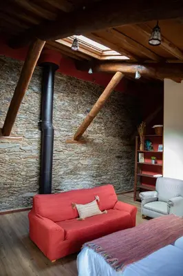 a red couch in a room with a brick wall at Casa Ría de Navia in Navia