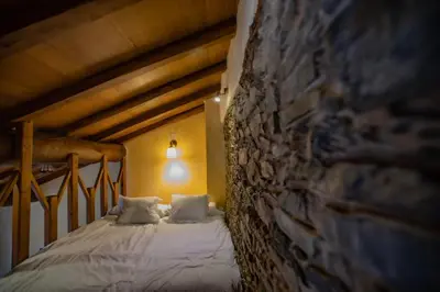 a bed in a room with a brick wall at Casa Ría de Navia in Navia