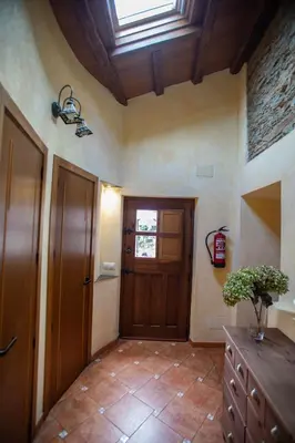 a hallway with a wooden door and a window at Casa Ría de Navia in Navia