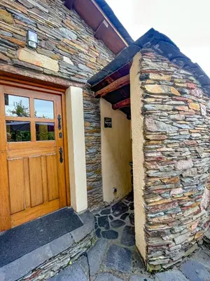 a building with a wooden door and a stone wall at Casa Ría de Navia in Navia