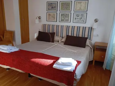 a bedroom with a bed with towels on it at Apartamentos el Camino in Villafranca del Bierzo