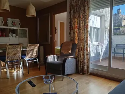a living room with chairs and a glass table at Apartamentos el Camino in Villafranca del Bierzo