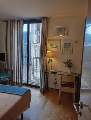 a bedroom with a bed and a desk with a window at Apartamentos el Camino in Villafranca del Bierzo