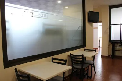 a meeting room with two tables and a large screen at Albergue Folgueira in Portomarin