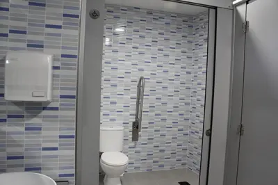 a bathroom with a toilet and a shower with blue tiles at Albergue Folgueira in Portomarin