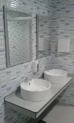a bathroom with two sinks and a mirror at Albergue Folgueira in Portomarin