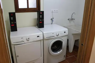 a laundry room with a washer and a washing machine at Albergue Folgueira in Portomarin