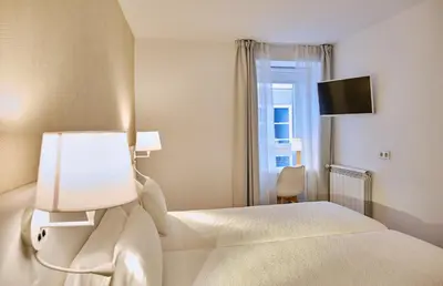 a hotel room with a bed and a window at Hostal Suso in Santiago de Compostela