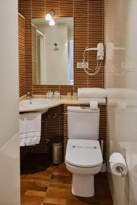 a bathroom with a toilet and a sink and a mirror at Hostal Suso in Santiago de Compostela