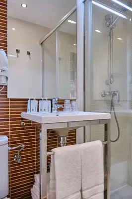 a bathroom with a white sink and a shower at Hostal Suso in Santiago de Compostela
