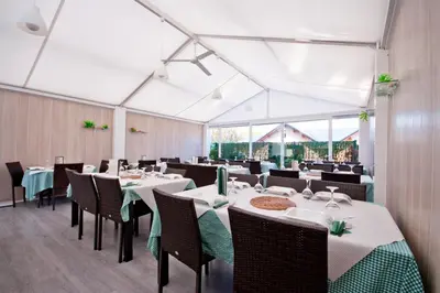 a dining room with white tables and chairs at Porto de Rinlo in Rinlo