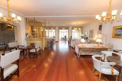 a living room with wooden floors and chairs and tables at Parador de Ribadeo in Ribadeo